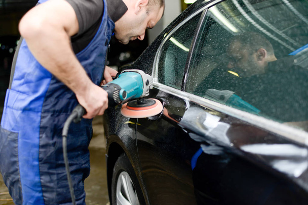 Man on a car wash polishing car with a polish machine - Photo, Image