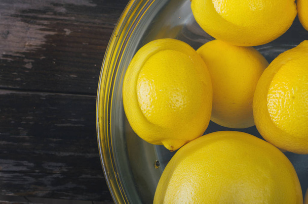 Un ramo de limón y pomelo en un tazón lleno de agua
.  - Foto, Imagen
