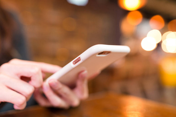 Femme envoyant des SMS sur téléphone portable dans le restaurant
 - Photo, image
