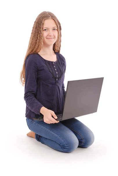 Student teenage girl sitting sideways on the floor with laptop - Fotó, kép
