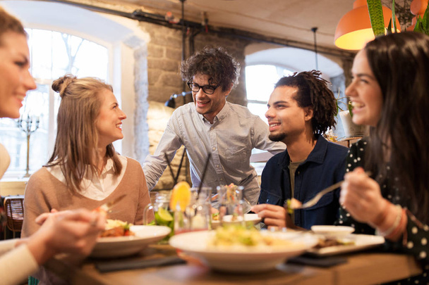 happy friends eating and drinking at restaurant - Valokuva, kuva