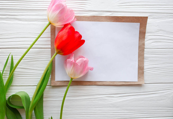 Houten witte achtergrond, brief en tulpen. 8 maart, Moederdag D - Foto, afbeelding