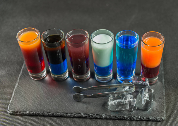 rechterkant weergeven op een zes verschillende gekleurde shot dranken, opgesteld - Foto, afbeelding