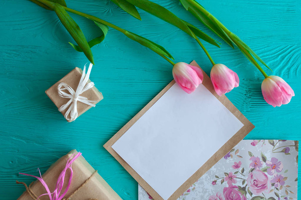 Houten witte achtergrond, brief en tulpen. 8 maart, Mother's Day. - Foto, afbeelding