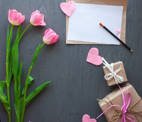 Drewniane białe tło, list i tulipany. 8 marca, dzień matki. - Zdjęcie, obraz