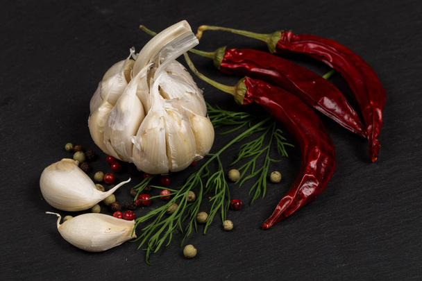 Seasoning ingredients for cooking - spices, pepper mix, chili pepper, garlic, dill. Top view on stone plate - Фото, зображення