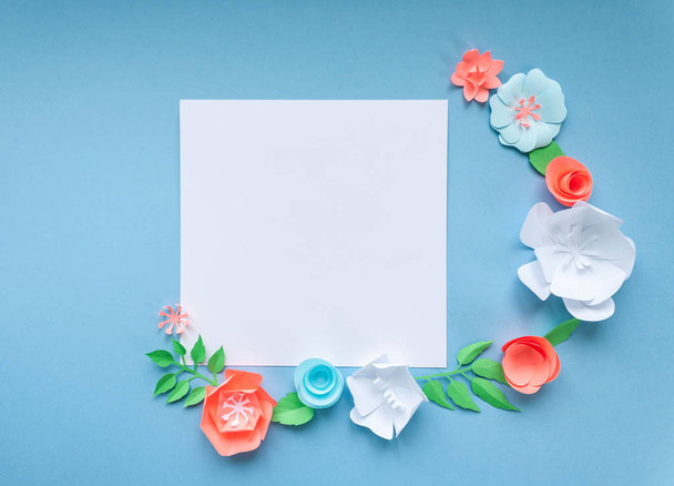 vierkante frame met kleur papier bloemen op de blauwe achtergrond. Flat lag. Natuur concept - Foto, afbeelding