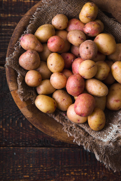 Raw potatoes red and white in a wooden bowl - Photo, image