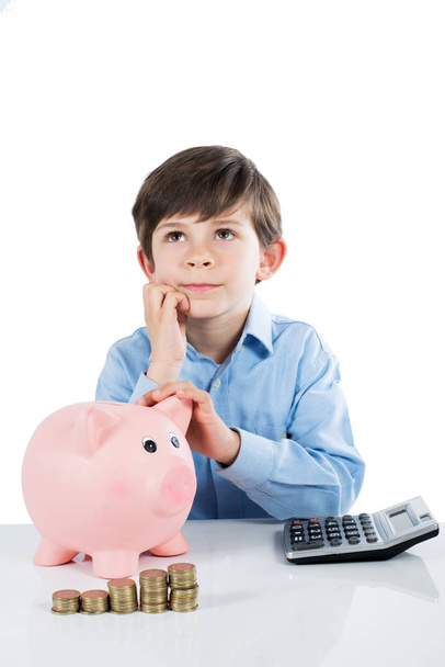 Boy with piggy bank thinking - Photo, Image