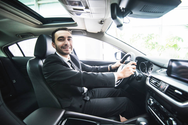 Driving with pleasure. Close-up of cheerful mature man in formalwear driving car and smiling - Fotó, kép