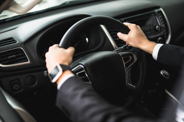 hand of a businessman at the wheel of a car - Fotó, kép