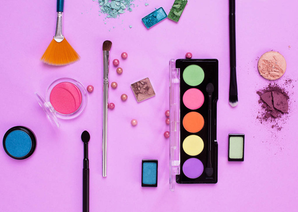 makeup cosmetics, brushes and shadows on pink background. Top vi - 写真・画像
