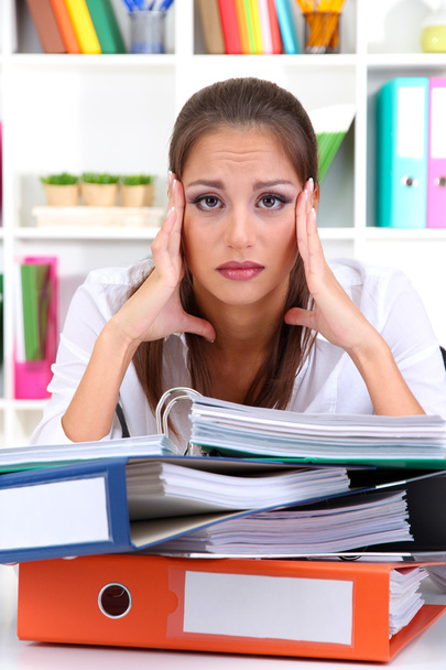 Tired business woman with documents in her workplace - 写真・画像