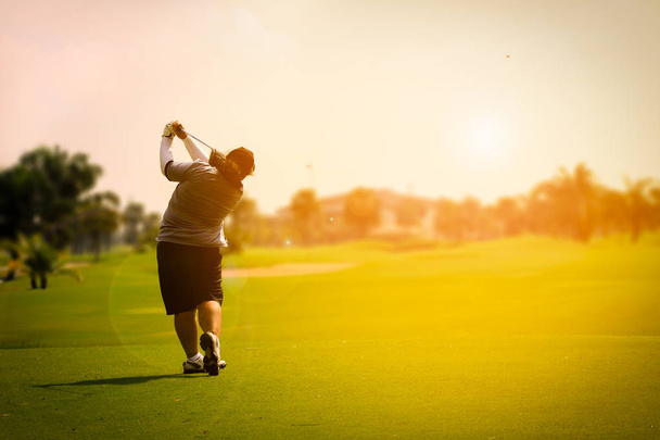 f して日没時にフェアウェイ ゴルフを振る女性ゴルフ選手 - 写真・画像