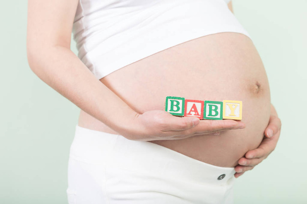 jonge mooie zwangere vrouw met blokjes - Foto, afbeelding
