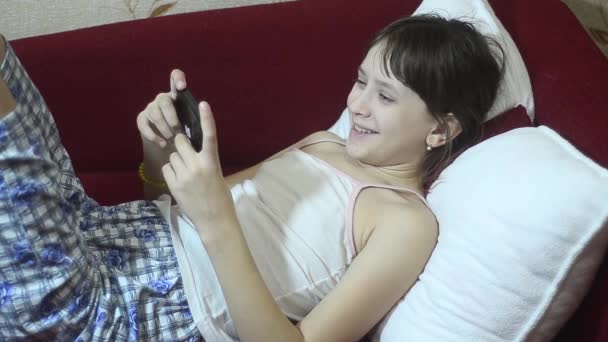 Teen dziewczyna komunikuje się w Internecie przez telefon. - Materiał filmowy, wideo