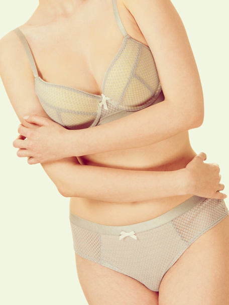 Attractive slim woman in grey matching underwear - 写真・画像