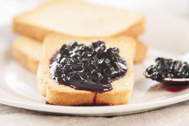 Delicious toast with jam on white plate, close-up - Valokuva, kuva