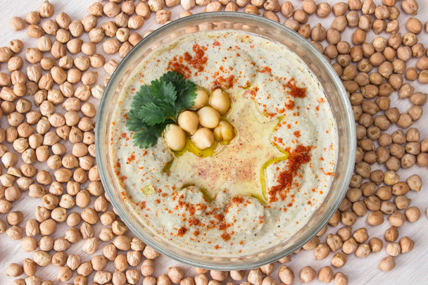 A bowl of creamy hummus with olive oil. - Zdjęcie, obraz