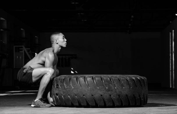 Personal trainer flipping a tyre - Photo, Image