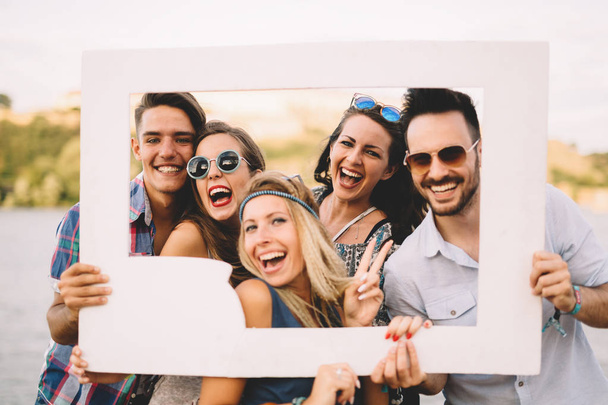 friends laughing and holding frame - Fotoğraf, Görsel