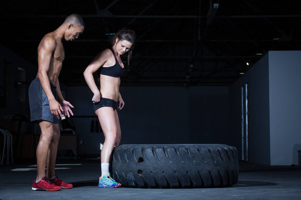 Personal trainer flipping a tyre - Foto, Bild