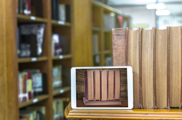 Tablet ordenador con libros antiguos
  - Foto, Imagen