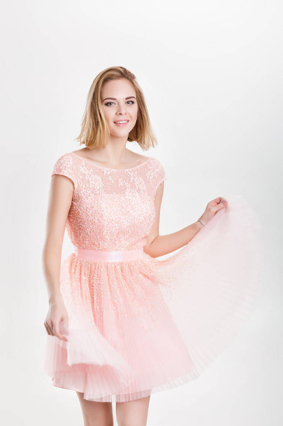beautiful blond woman in a pink cocktail dress dancing and havin - Foto, afbeelding