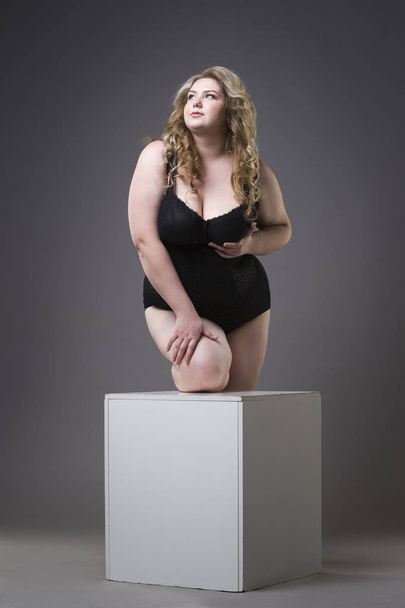 Young beautiful blonde plus size model in shapewear, xxl woman in slimming underwear on gray studio background - Photo, Image