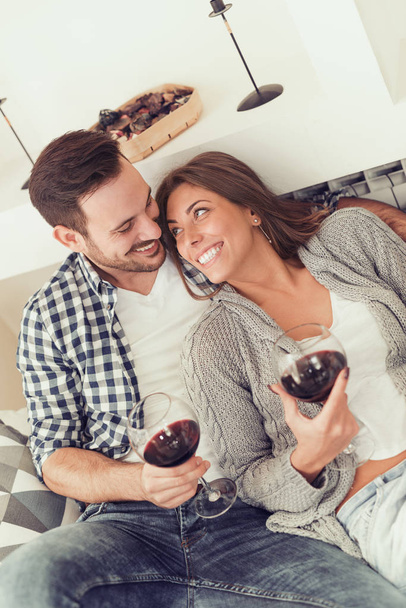 Primer plano de una joven pareja disfrutando del vino en casa
 - Foto, imagen