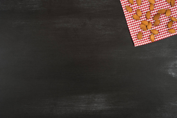 Almonds on a kitchen napkin and black chalkboard. - Foto, afbeelding
