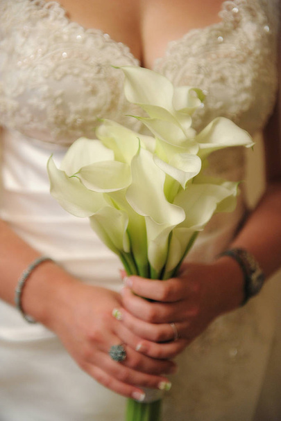Menyasszony kezében egy elegáns calla liliom csokor  - Fotó, kép