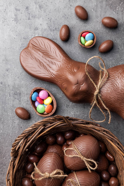 Chocolate Easter bunny and eggs on wooden background - Фото, изображение