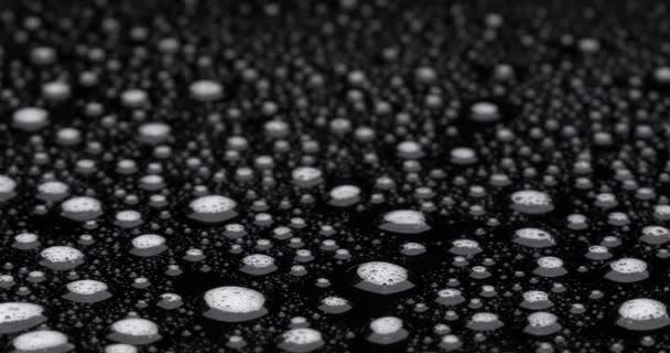 Seifenwassertropfen rotieren auf schwarzer Oberfläche - Filmmaterial, Video