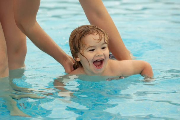 かわいい男の子の母親の助けを借りて泳ぐことを学び - 写真・画像