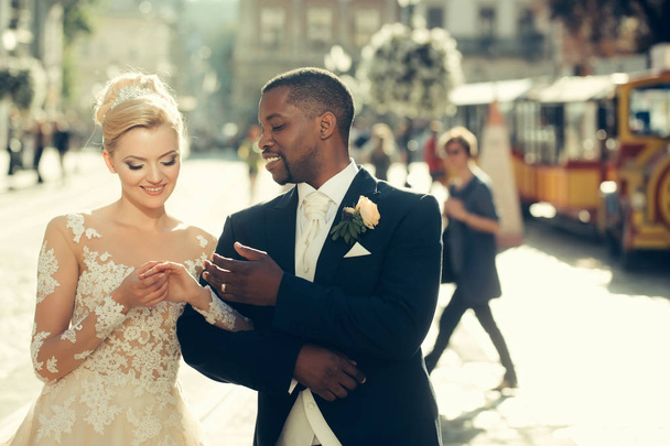 Happy african American groom and cute bride walking on street - Foto, immagini