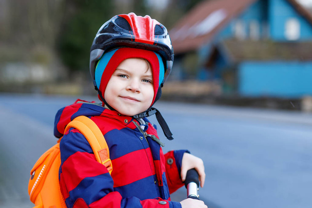 Милый маленький дошкольный мальчик едет на скутере в школу
. - Фото, изображение