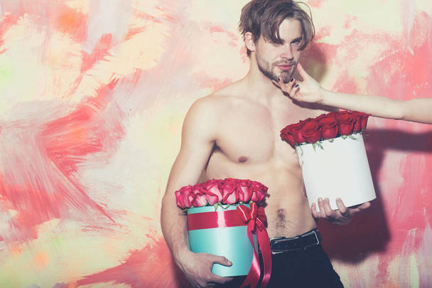 bearded muscular man with sexy body holds red rose box - Foto, Imagem