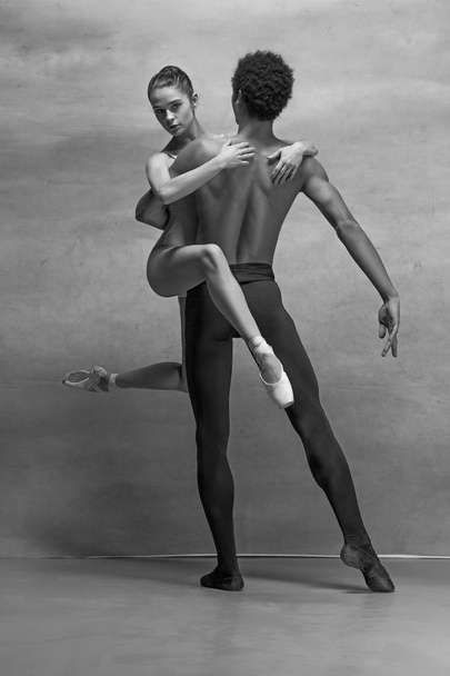 Couple of ballet dancers posing over gray background - Φωτογραφία, εικόνα