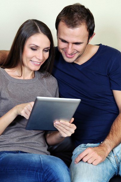 Couple using a tablet computer in their living room - Photo, Image