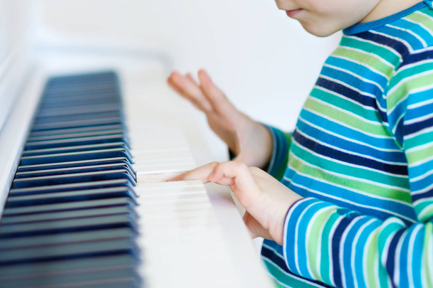 Szép kis gyerek fiú nappaliban vagy a Zeneiskolában zongorázni - Fotó, kép