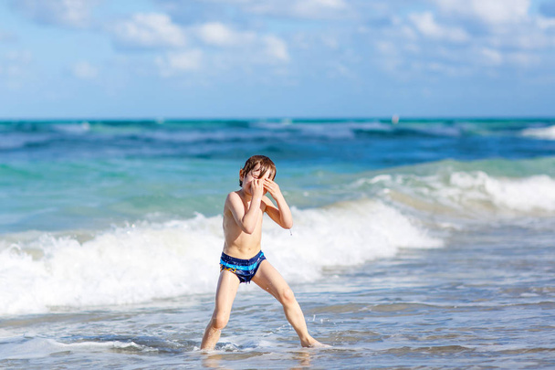 pequeno menino loiro se divertindo na praia do oceano na Flórida
 - Foto, Imagem