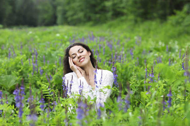 Mujer morena bonita feliz en el campo de flores
 - Foto, imagen