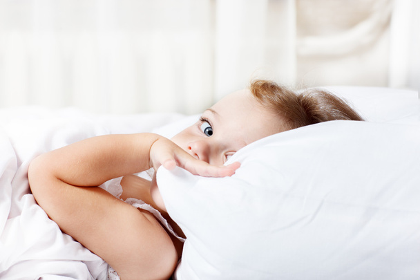 Toddler hiding behind pillow - Фото, изображение