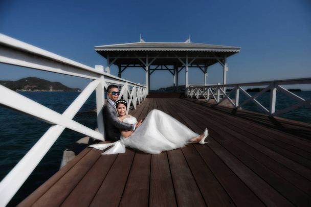 Pre-Wedding Fotografie thailändische Paare auf einer hölzernen Atsadang-Brücke der Insel Koh si chang in Thailand in Konzept Liebe zur Erinnerung. - Foto, Bild