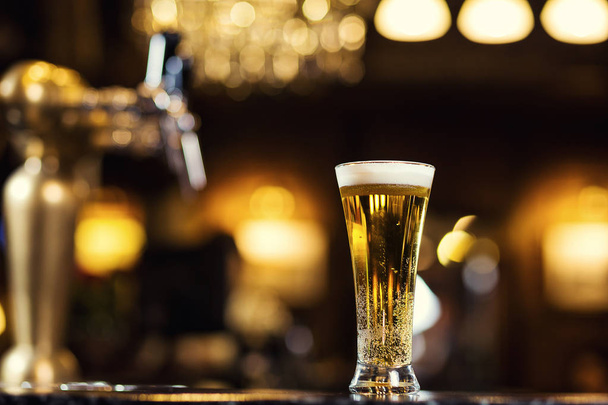 Beer, a glass of fresh cold beer on the bar.A pub.Bar.Restaurant.Classic.Evening.European restaurant.European bar.American restaurant.American bar.strong drin - Photo, Image