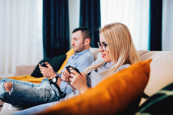 Muotokuva nuoresta parista pelaamassa videopelejä digitaalisella konsolilla. yksityiskohdat modernin elämäntavan
 - Valokuva, kuva