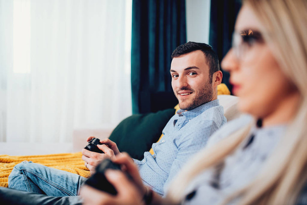 portrait of attractive man playing video games with blonde wife - Fotografie, Obrázek