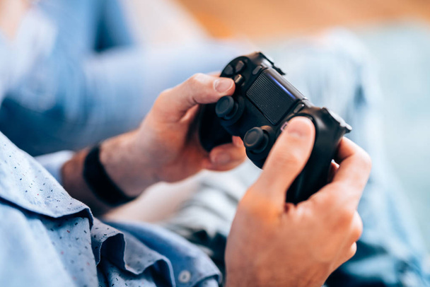 Modern lifestyle concept - Male playing with controller, playing video games on tv and enjoying free time - Foto, Imagem