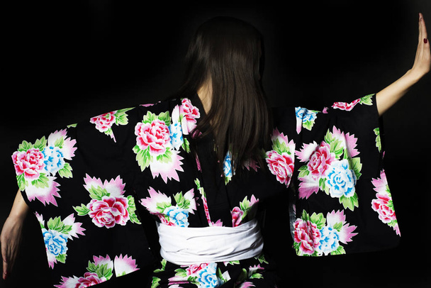 Japanese girl in traditional Japanese kimono on black background - Фото, изображение